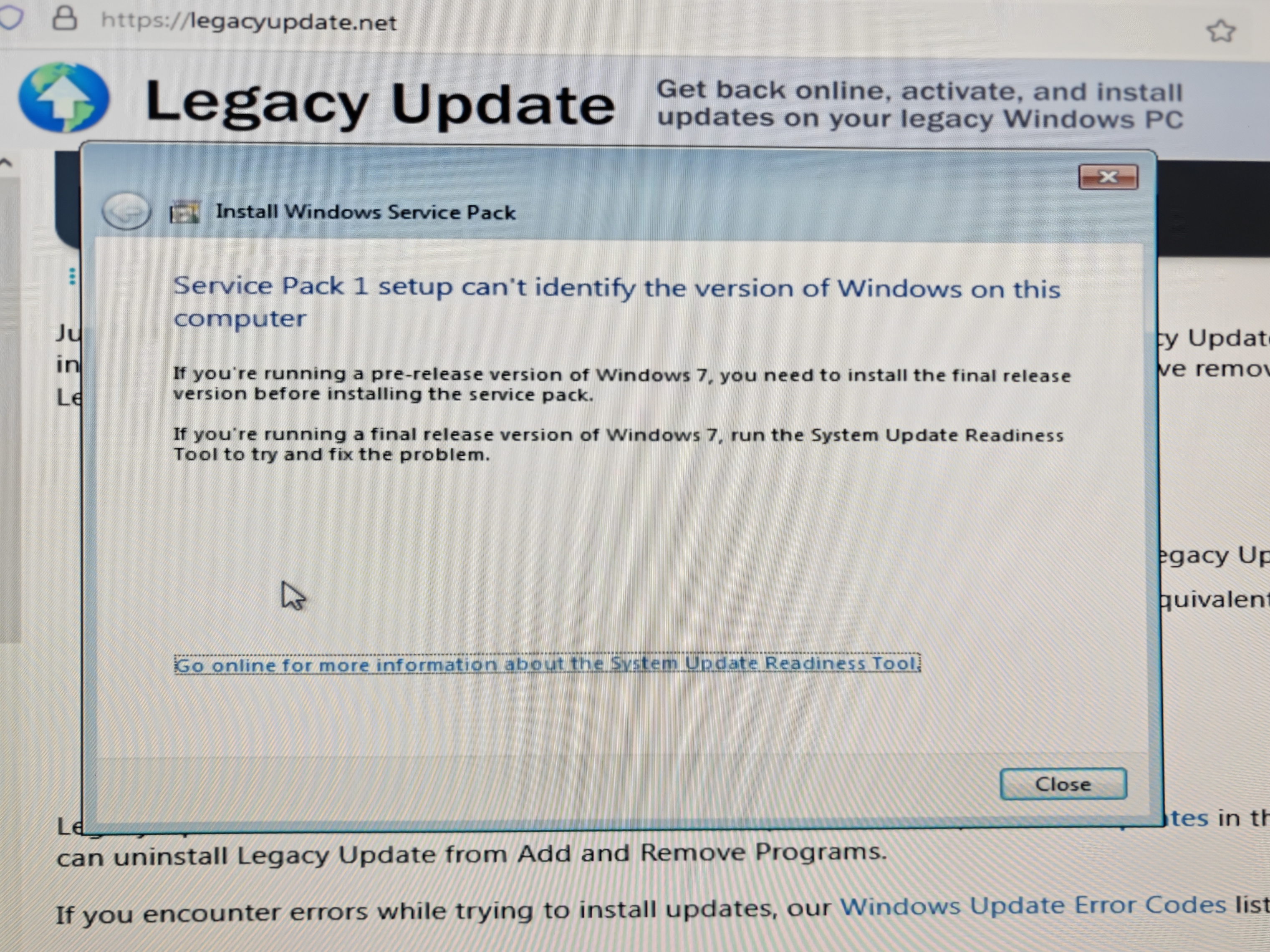 The installer for Windows 7 Service Pack 1 is in the foreground, overlaid on IE8 which is open on legacyupdate.net. The installer shows the following error: Service Pack 1 setup can't identify the version of Windows on this computer. If you're running a pre-release version of Windows, you need to install the final release version before installing the service pack. If you're running a final release version of Windows 7, run the System Update Readiness Tool to try and fix the problem.